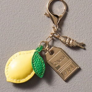 Leather lemon keychain bag charm with green leaves and golden fish pendant detail