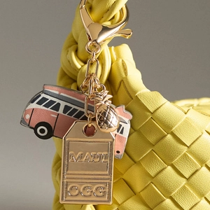Yellow woven handbag charm featuring a vintage bus and pineapple with MAUI gold tags