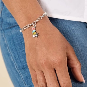Silver chain bracelet with colorful MAMA crown pendant worn by a model in casual style
