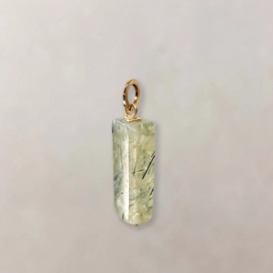 Detailed macro view of a rectangular green natural stone pendant with gold metal ring