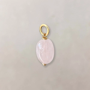 Macro detail of oval rose quartz pendant with gold wire wrapped top for DIY necklaces