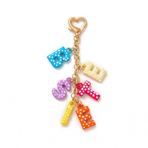 Détail macro du porte-clés BESTIE multicolore à pois blancs avec fermoir coeur doré