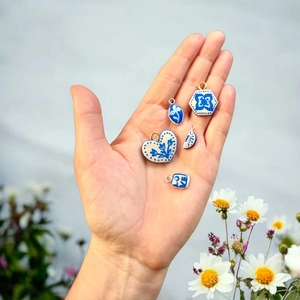 Set di cinque ciondoli in ceramica bianca e blu con motivi floreali e scritte d'amore