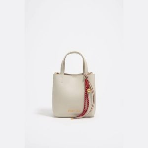 Détail du sac seau beige avec corde tressée rouge et blanc et accents de perles dorées