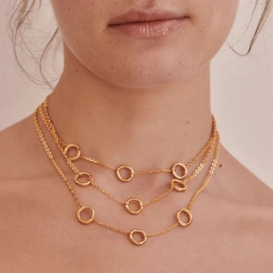 Three-layer 18k gold plated titanium steel necklace with small ring accents on a model