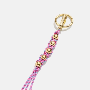 Detail of pink and blue woven rope keychain with polished gold beads and metallic clasp