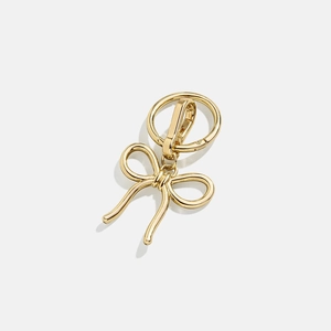 Close-up of polished gold bow keychain with lobster clasp and round key ring