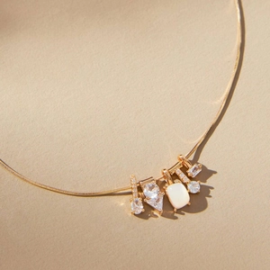 Detail of 14k gold plated snake chain with sparkling zircon charms and opal pendant