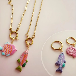 Macro detail of 18K gold paperclip chain and colorful sea life charms for DIY jewelry