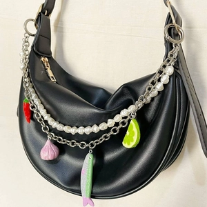 Détail du sac lune noir avec chaînes argentées et breloques colorées amusantes