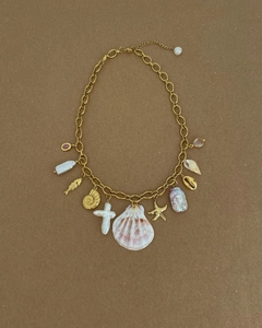 Détails du collier en chaîne dorée avec perles baroques, pendentifs coquillages et étoiles