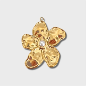 Vue détaillée d'un pendentif fleur dorée avec texture martelée et accent de perle