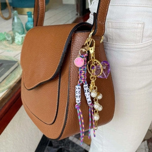 Pendentif de sac coloré Just Smile avec smiley rose et cœur violet sur un sac marron