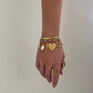 Ensemble bracelet multirang à breloques cœur et bagues dorées sur un mannequin
