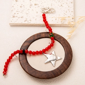 DIY jewelry beaded necklace with red glass beads and a shiny silver star pendant