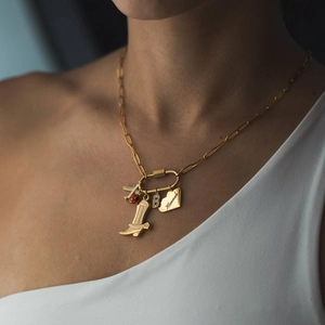 Détail de la chaîne à maillons dorée 18 carats avec pendentifs botte, lettre B et Hannah