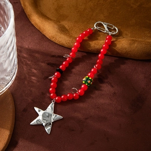 Detail of a handmade red glass beaded keychain with a shiny silver star pendant