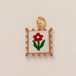 Détail d'un pendentif timbre avec motif floral et bordure à paillettes brunes