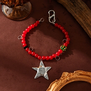 Detail of red beaded DIY bracelet featuring a silver star charm and lobster clasp closure