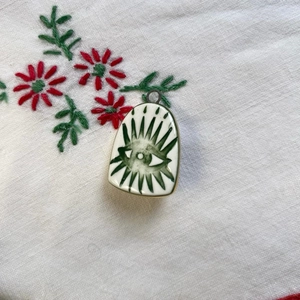 Primer plano del colgante de ojo turco sobre tela bordada con flores