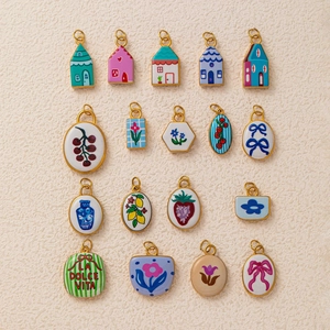 Detail of colorful enamel charms with hand-painted floral, house, and fruit patterns