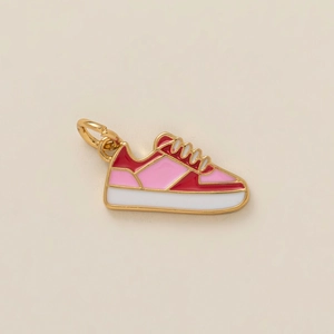Macro-opname van een roze en rode sneaker hanger met vergulde metalen randen