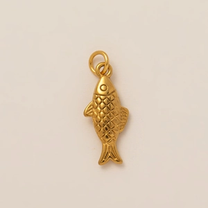 Macro view of 18K gold plated fish pendant showing detailed scales and carving texture