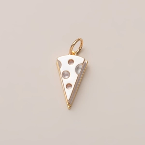 Macro detail of cheese-shaped gold pendant with smooth cream enamel finish