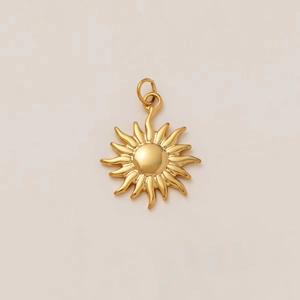 Gros plan d'un pendentif soleil plaqué or 18k avec rayons ondulés sur fond blanc
