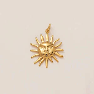 Détail macro du pendentif visage du dieu soleil plaqué or 18k avec rayons radieux