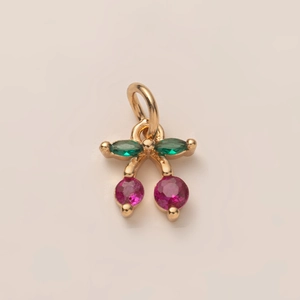 Detailopname van kersenhanger met roze en groene kristallen in verguld messing