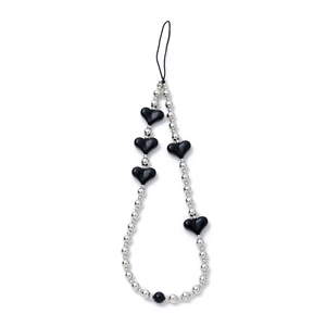 Detail of silver beads and black heart charms on a creative handmade phone strap