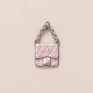 Detailed view of silver handbag pendant with pink enamel and quilted texture