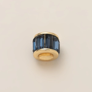 Detalle de abalorio cilíndrico dorado con cristales azules para la creación de joyería