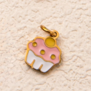 Macro detail of a 18K gold-plated cupcake pendant with pink and white enamel decoration