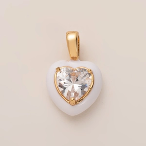 Detalle de un colgante de corazón blanco con borde dorado y circonita en forma de corazón