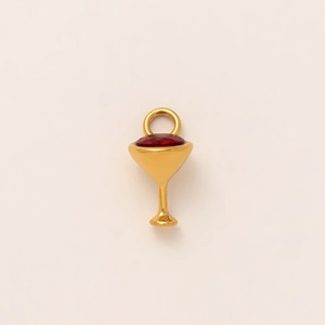 Macro view of a 18K gold-plated wine glass pendant with a sparkling red gemstone insert