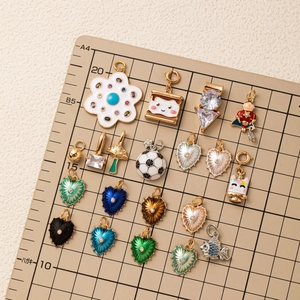 Συλλογή από πολύχρωμα σμαλτωμένα μενταγιόν σε σχήμα καρδιάς και ψαριού σε πίνακα μέτρησης