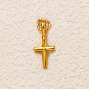 Gros plan détaillé d'un pendentif en croix plaqué or avec une texture de métal martelé
