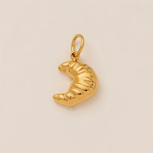 Detailed view of an 18K gold plated croissant pendant with realistic pastry textures