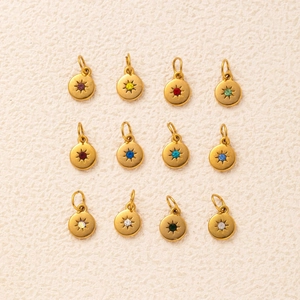 Macro shot of twelve vintage gold starburst charms with colorful birthstone crystals