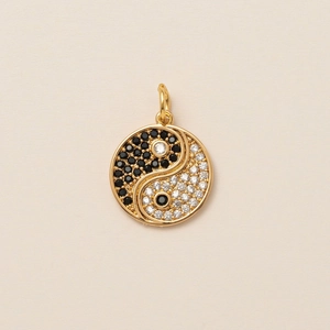 Macro detail of Yin Yang pendant with black and white pavé stones in gold finish