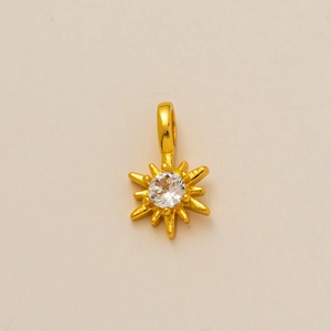 Détail du pendentif rayons de soleil doré avec une pierre précieuse sertie au centre