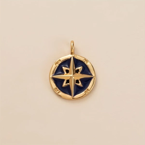 Detail of gold compass pendant with blue enamel and engraved nautical directions