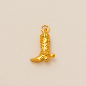 Détail du pendentif botte de cowboy plaqué or avec motifs en relief et éperon rotatif