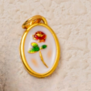 Dettaglio del ciondolo ovale placcato oro 18K con rosa in smalto rosso e foglie verdi