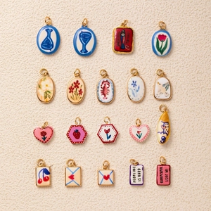 Detail of colorful ceramic charms with gold metal frames and hand-painted floral motifs