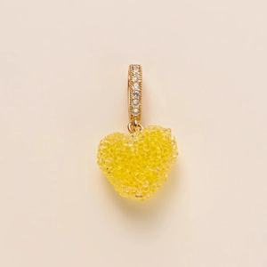 Macro view of a faceted yellow heart pendant with a sparkling gold cubic zirconia bail