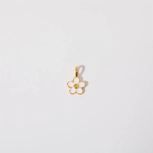 Detail of flower charm with white enamel and gold finish on high-quality stainless steel