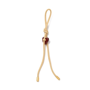 Détail d'un porte-clés en corde tissée avec perle cœur rouge et embouts dorés